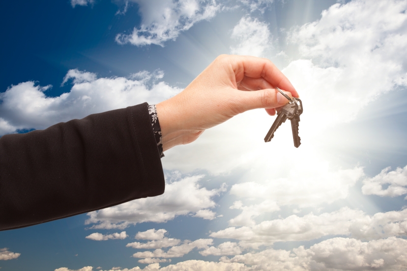 -female-holding-out-pair-of-keys-over-clouds-and-sky
